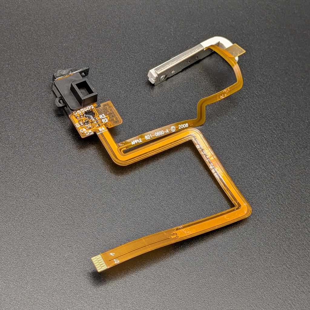 A replacement flex cable assembly for an iPod, featuring a gold-orange ribbon cable, a black plastic button housing, and a silver metal connector, shown on a dark textured background.