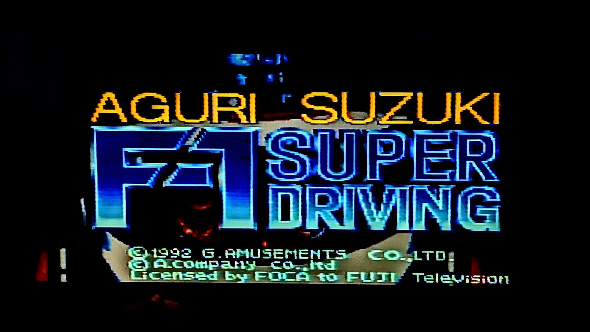 The game title screen for 'Aguri Suzuki F1 Super Driving' for the Super Famicom (SFC) featuring stylized blue and white 3D lettering with yellow text on a black background, with copyright details for G. Amusements Co.