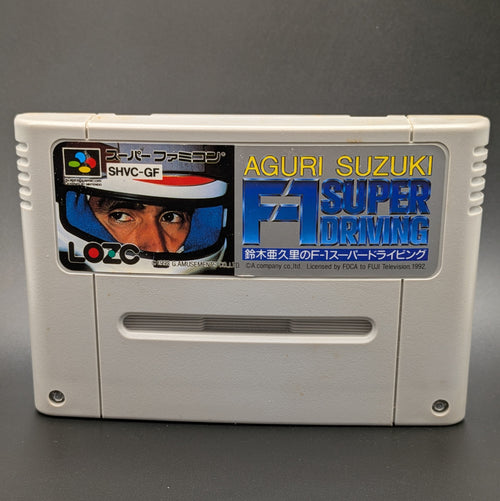 A close up of Aguri Suzuki F-1 Super Driving video game cartridge for Nintendo's Super Famicom (SFC) Entertainment System, shown standing up and facing forward on a dark grey background.
