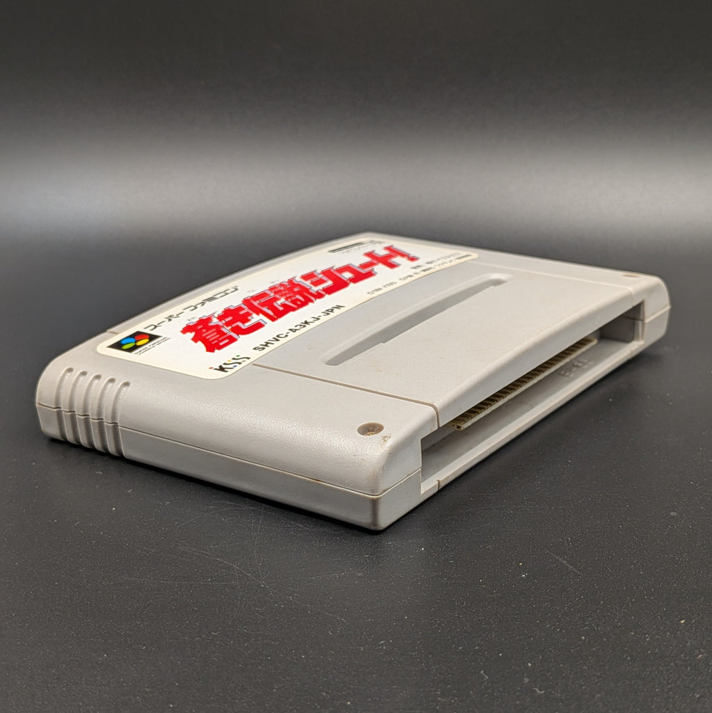Aoki Densetsu Shoot video game cartridge for Nintendo's Super Famicom (SFC) Entertainment System, shown laying on its back with the label facing upwards. Showing the left hand side and bottom slot. It sits on a dark grey background