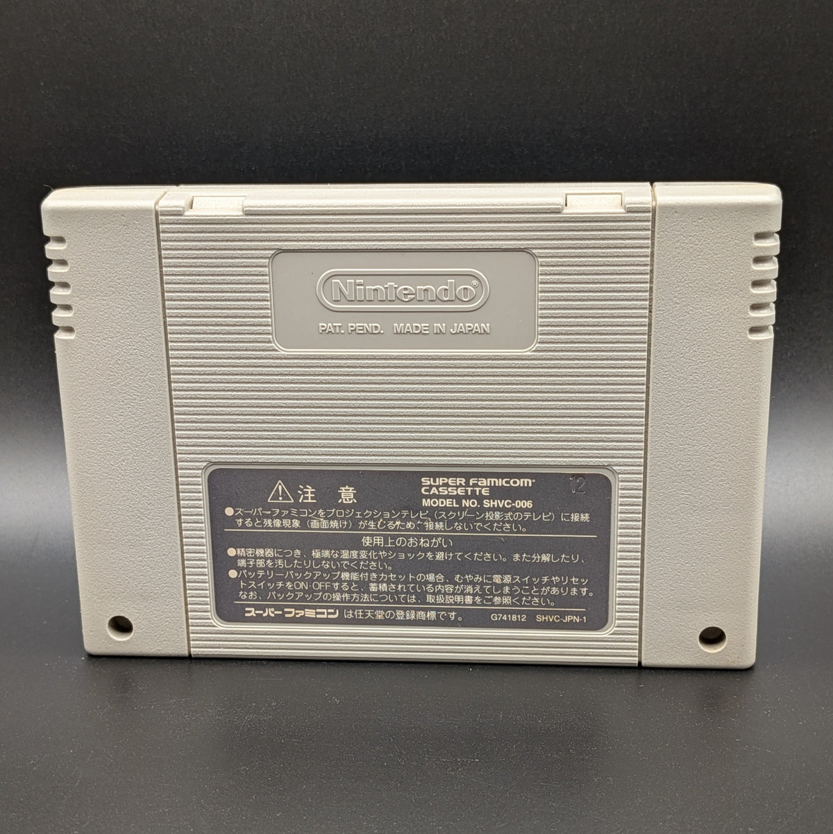 Bahamut Lagoon video game cartridge for Nintendo's Super Famicom (SFC) Entertainment System, showing the back of the cartridge. It sits on a dark grey background.