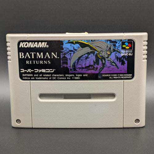 A close up of Batman Returns video game cartridge for Nintendo's Super Famicom (SFC) Entertainment System, shown standing up and facing forward on a dark grey background.