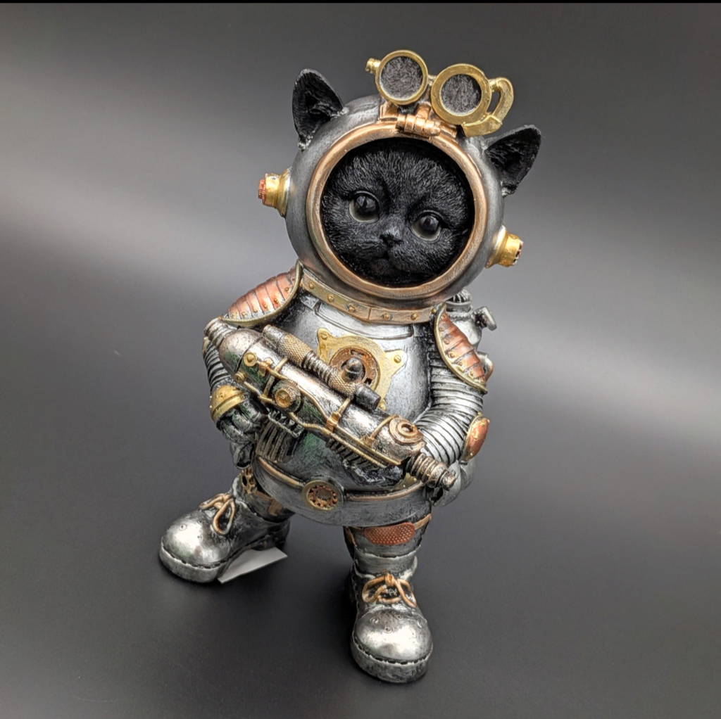 A black cat dressed as an astronaut, standing on a dark gray gradient background. The cat wears a detailed silver and bronze space suit with gold accents, goggles on the helmet, and holds a futuristic gun.