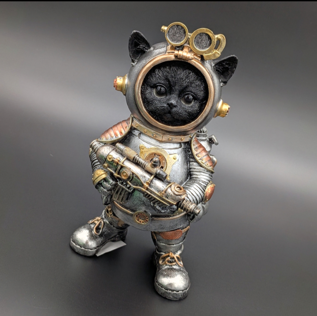 A black cat dressed as an astronaut, standing on a dark gray gradient background. The cat wears a detailed silver and bronze space suit with gold accents, goggles on the helmet, and holds a futuristic gun.