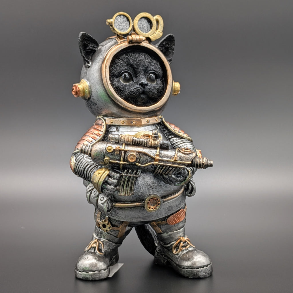 A black cat figurine dressed in a detailed steampunk-style space suit, holding a futuristic gun, set against a dark gray gradient background.