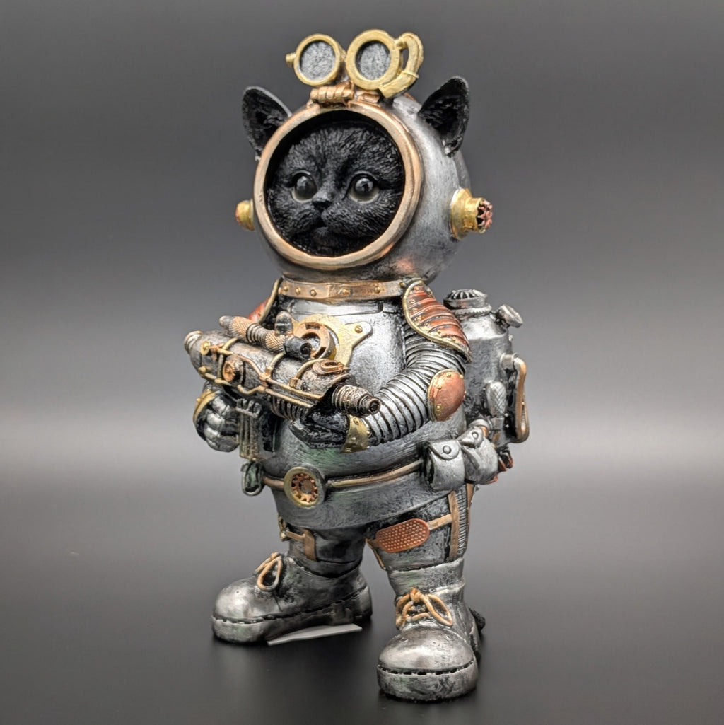 A decorative figurine of a black cat dressed in a detailed steampunk-style space suit, standing against a dark gray gradient background.