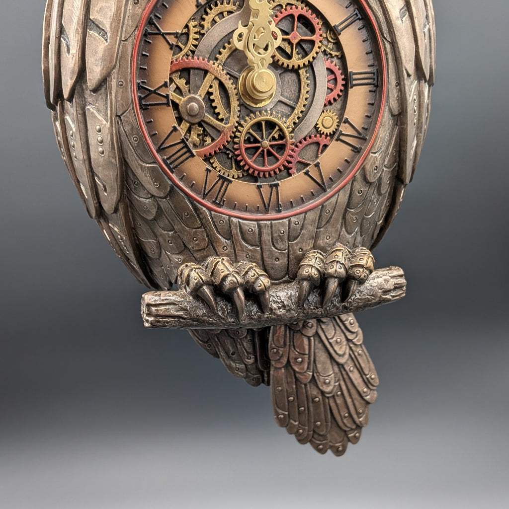 Steampunk owl wall clock with intricate  gears, Roman numerals, and a detailed owl body perched on a branch, shown against a dark gray gradient background.