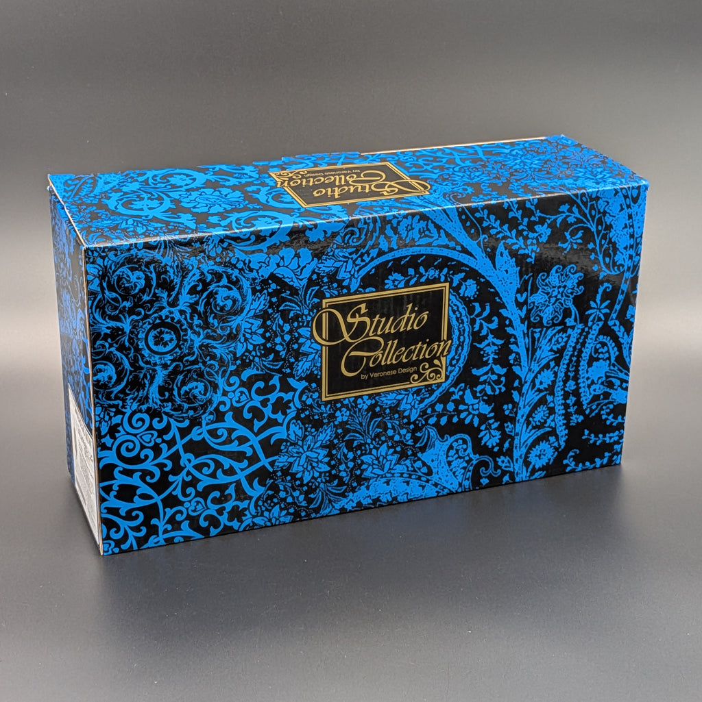 A rectangular product box with a blue and black ornate paisley pattern and gold 'Studio Collection' branding, photographed on a dark gray studio background.