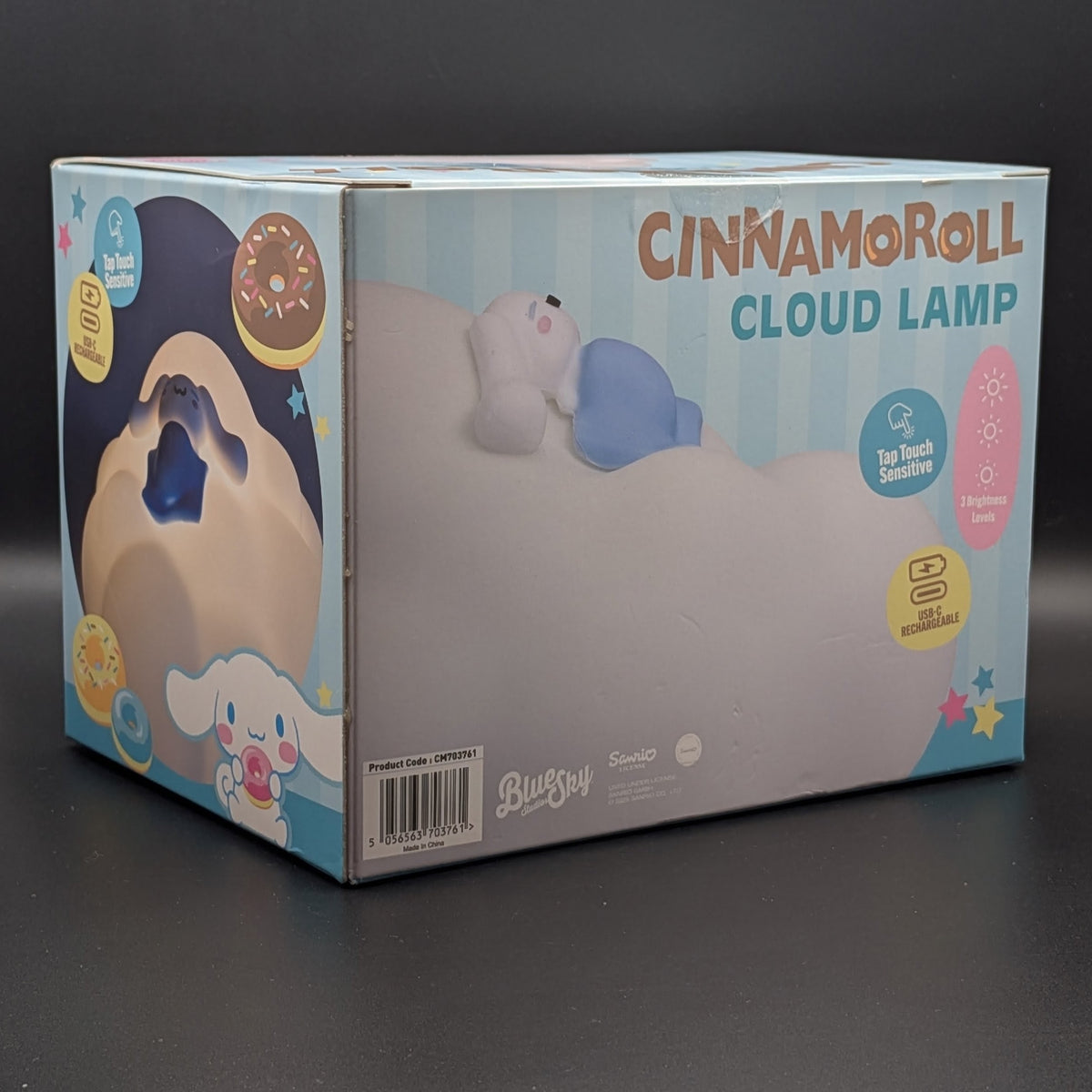 Cinnamoroll Cloud Lamp retail packaging box, featuring illustrations of the character and product details, photographed on a dark gray surface.