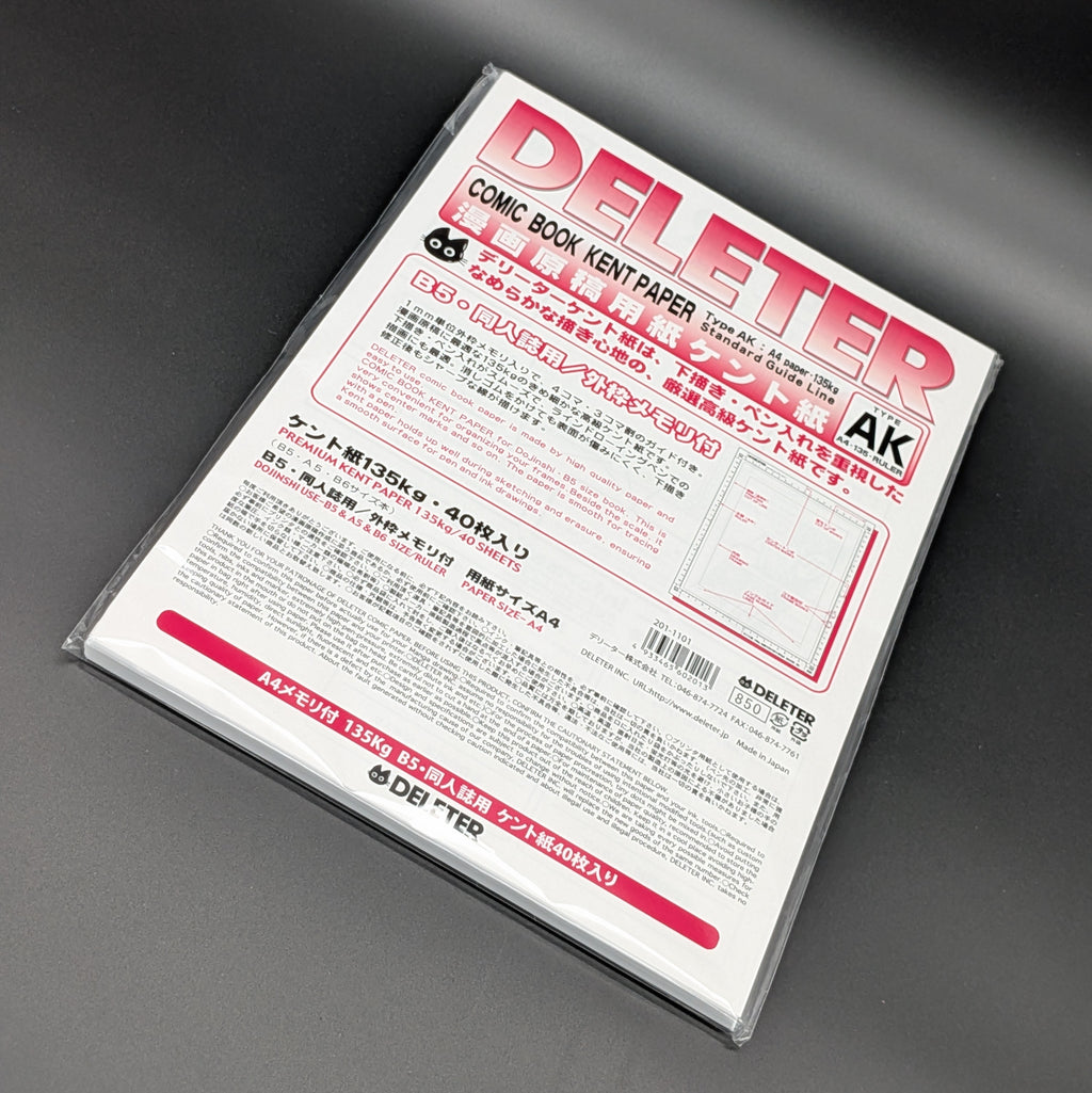 A sealed package of Deliter Comic Book Kent Paper, Type AK, containing 40 sheets of 135g premium paper. The packaging is white with bold pink and black text, the paper is leaning dramatically to the right and photographed on a grey background.