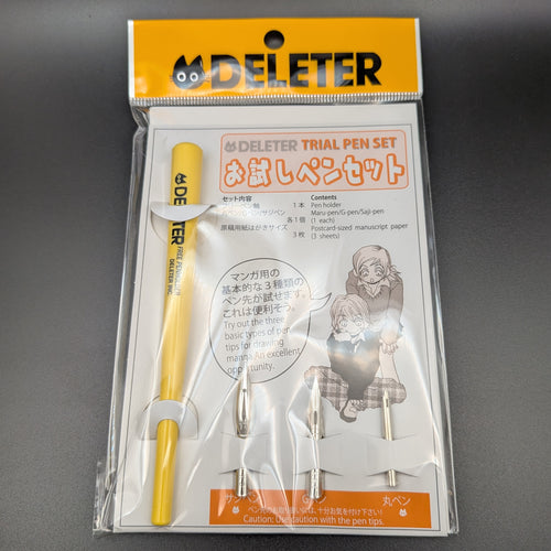DELETER Trial Pen Set in its original retail packaging, featuring a yellow pen, 3 pen nibs, manuscript paper, with a white and orange card insert. A close up image, taken on a black background.