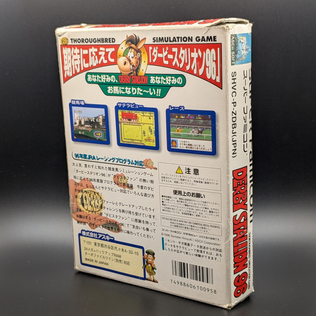 Derby Stallion 96 boxed, a video game for Nintendo's Super Famicom (SFC) Entertainment System, shown standing up to reveal the back of the box on a dark grey background. Slight wear and tear at the edges form age.
