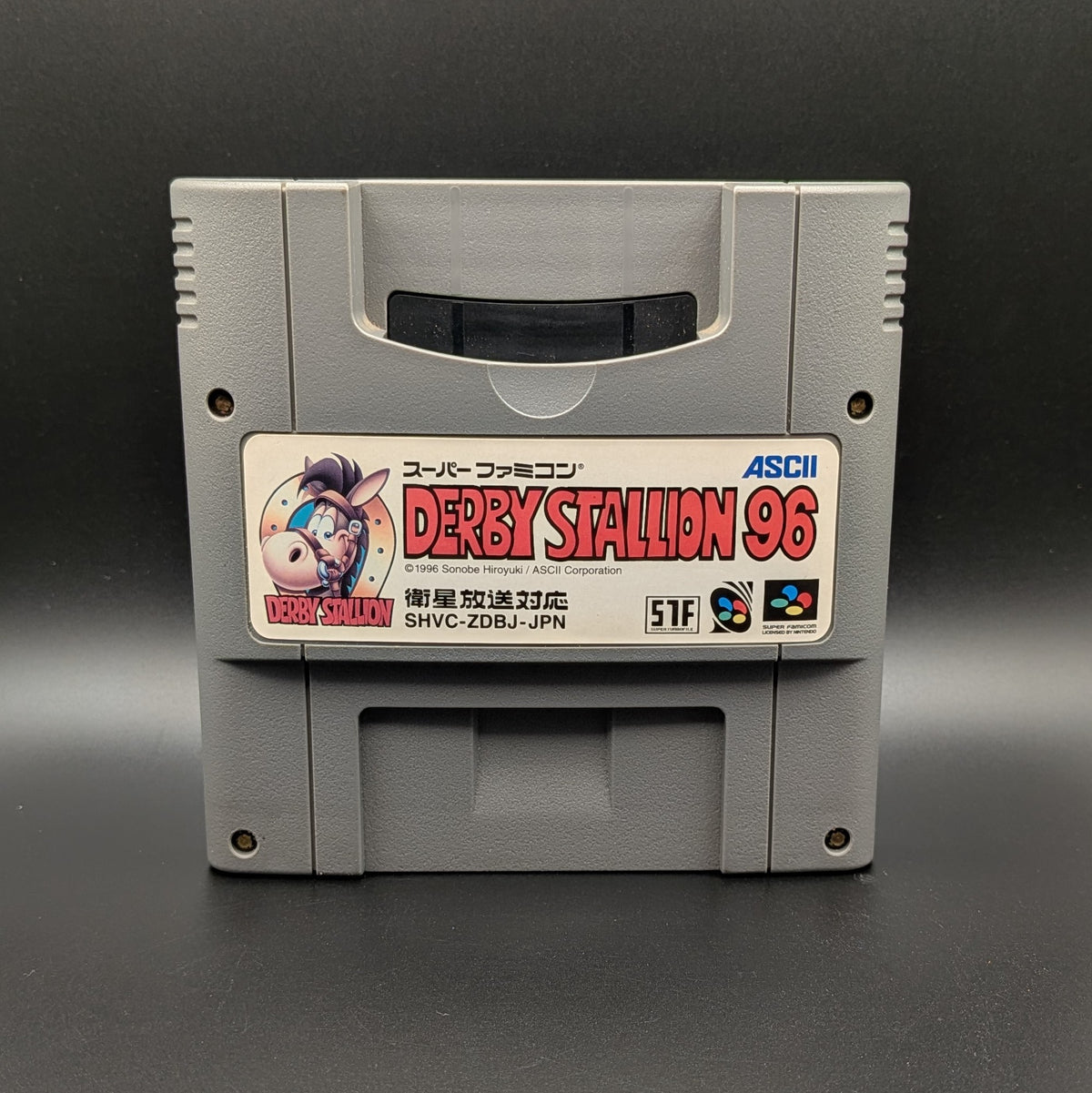 Derby Stallion 96' video game cartridge for Nintendo's Super Famicom (SFC) Entertainment System, shown standing up and facing forward on a dark grey background.
