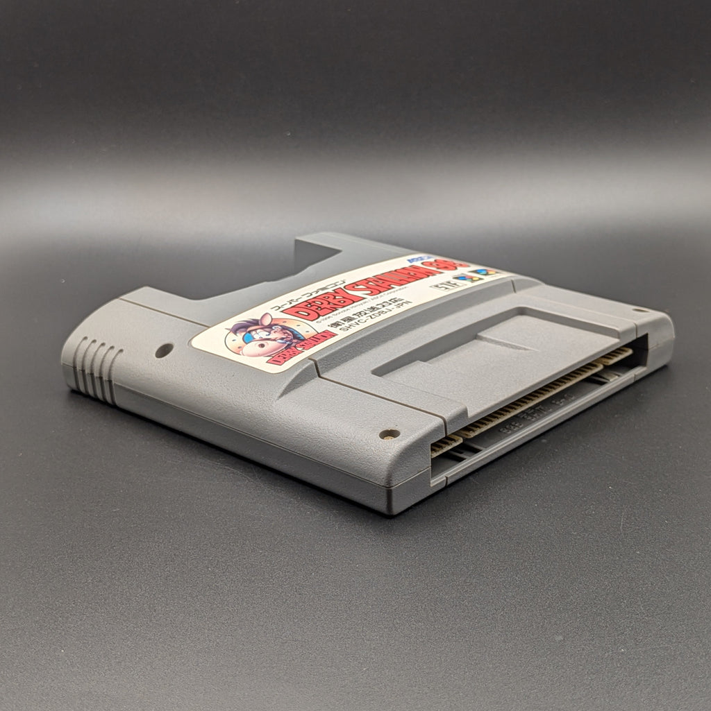 Derby Stallion 96 video game cartridge for Nintendo's Super Famicom (SFC) Entertainment System, shown laying on its back with the label facing upwards. Showing the left hand side and bottom slot. It sits on a dark grey background.