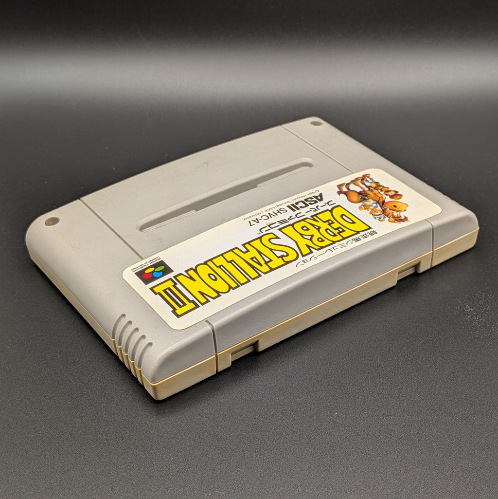 Derby Stallion 2 video game cartridge for Nintendo's Super Famicom (SFC) Entertainment System, shown laying on its back with the label facing upwards. Showing the right hand side and top edge. It sits on a dark grey background.