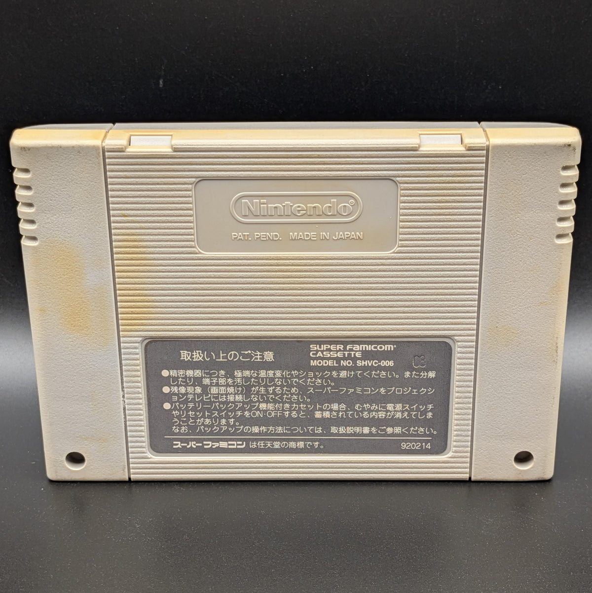 Derby Stallion 2 video game cartridge for Nintendo's Super Famicom (SFC) Entertainment System, shown from the back, there is patchy yellowing on the back panel. Displayed on a dark grey background.