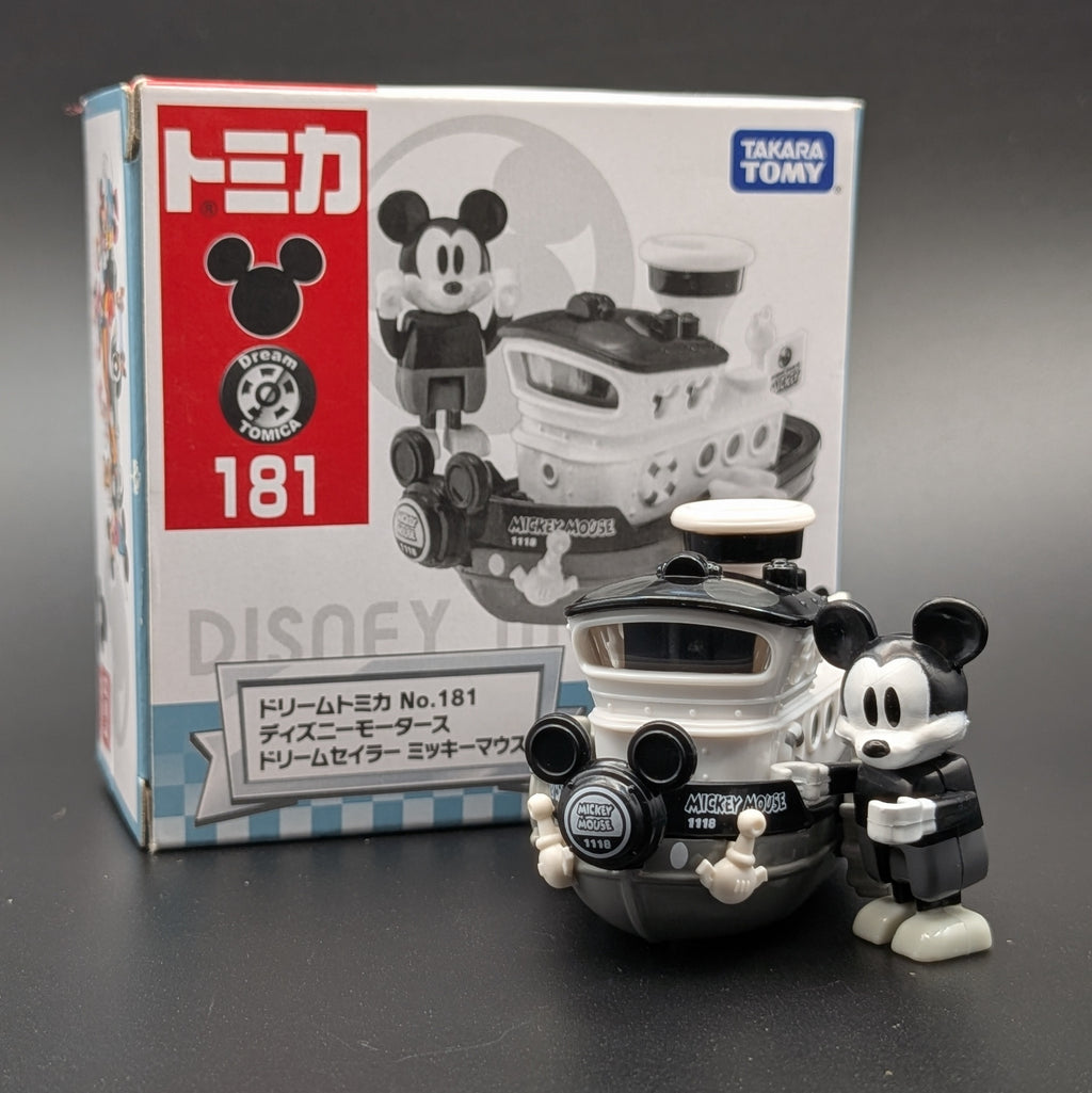 Takaoka Tomy Tomica Disney Mickey Mouse Steamboat Willie set, showing the box with number 181 and the toy figure of Mickey and his boat on a dark gray background.
