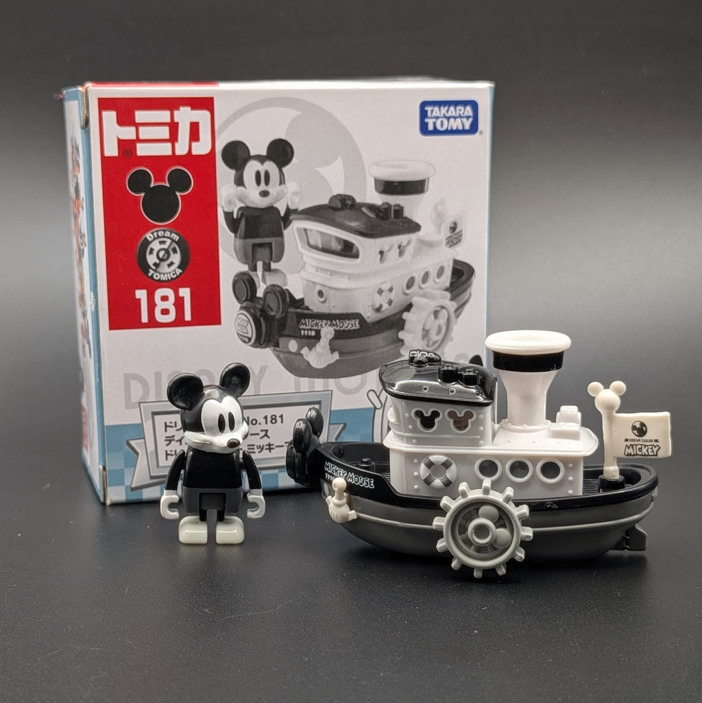 TOMICA Disney Mickey Mouse  set number 181, showing the black and white Mickey figure, the black and white boat, and the original product packaging box on a dark gray background.