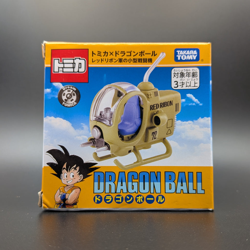TOMICA x Dragon Ball red ribbon toy model in its original Japanese packaging, featuring Goku on the box art against a dark gray background.
