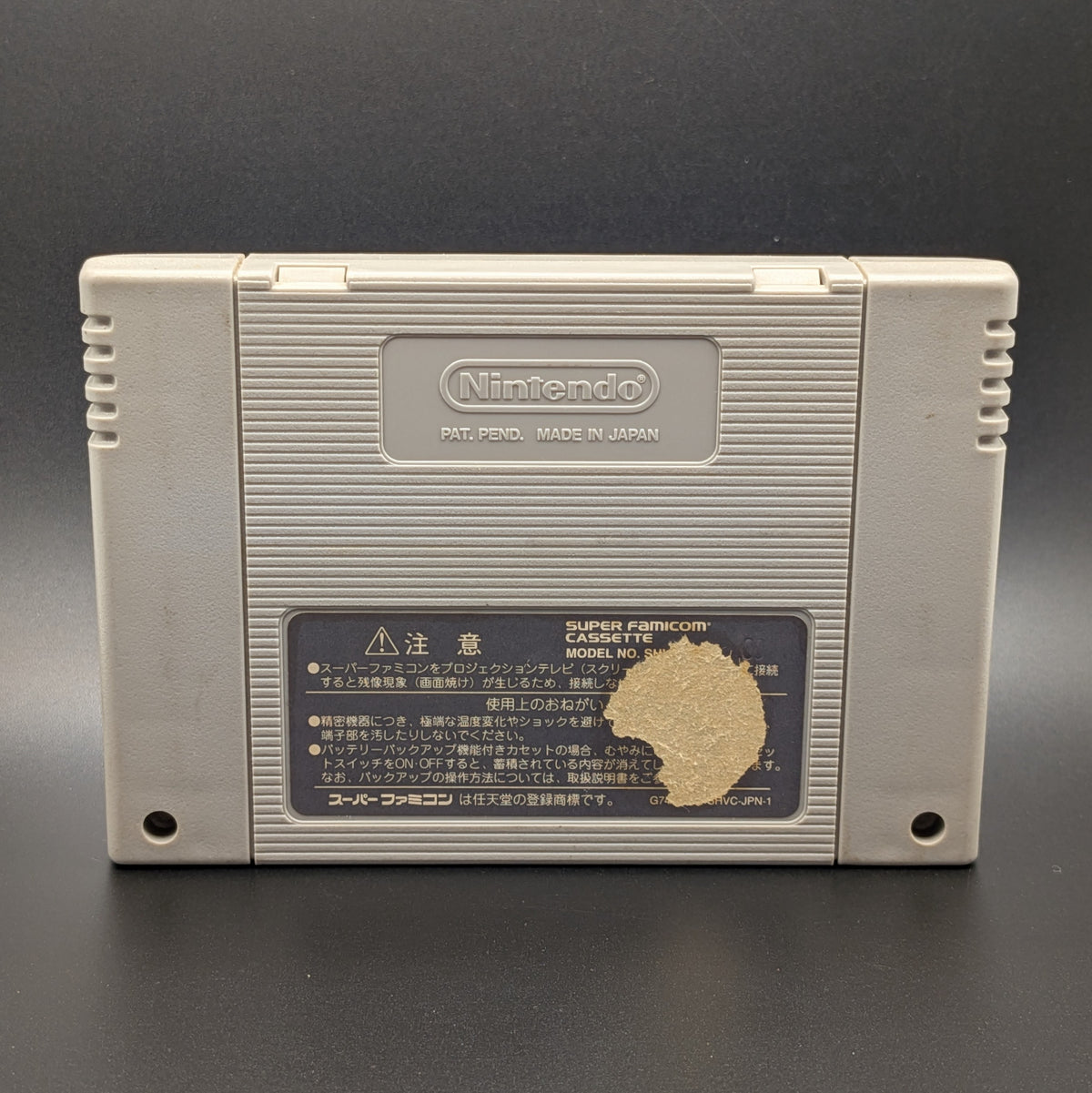 Dragon Quest 6 video game cartridge for Nintendo's Super Famicom (SFC) Entertainment System, showing the back of the cartridge. The back label has a round section missing to the right side of the label. It sits on a dark grey background.