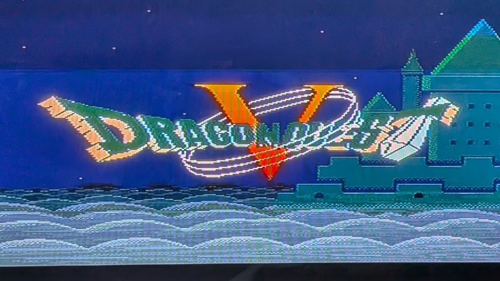A game title screen for Nintendo's Dragon Quest 5 on the Super Famicom (SFC), featuring the words 'Dragon Quest V' in stylized green and orange lettering, with a castle on the right, set against a dark blue night sky and wavy white clouds at the bottom.