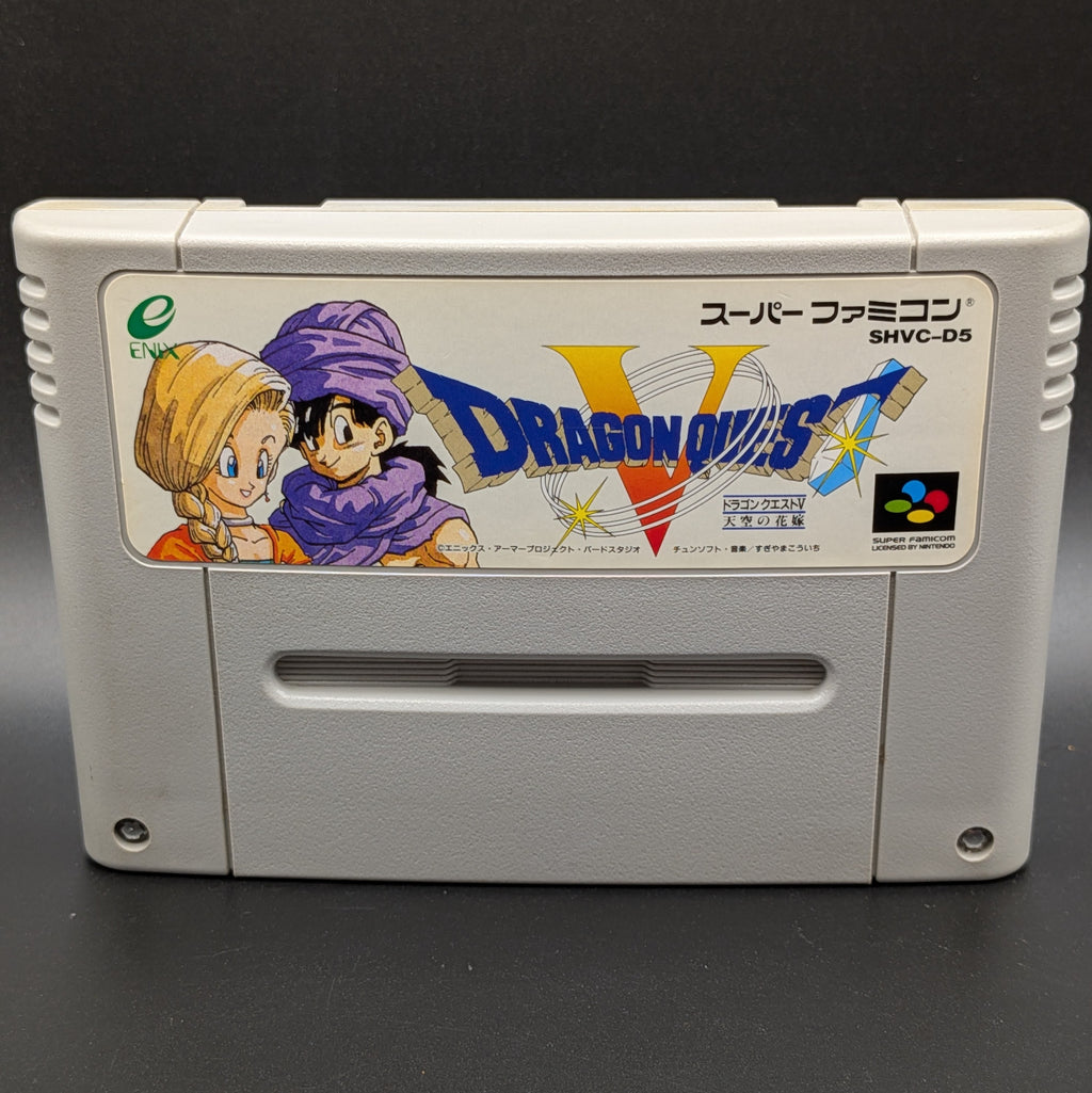 A close up of Dragon Quest V video game cartridge for Nintendo's Super Famicom (SFC) Entertainment System, shown standing up and facing forwards on a dark grey background.