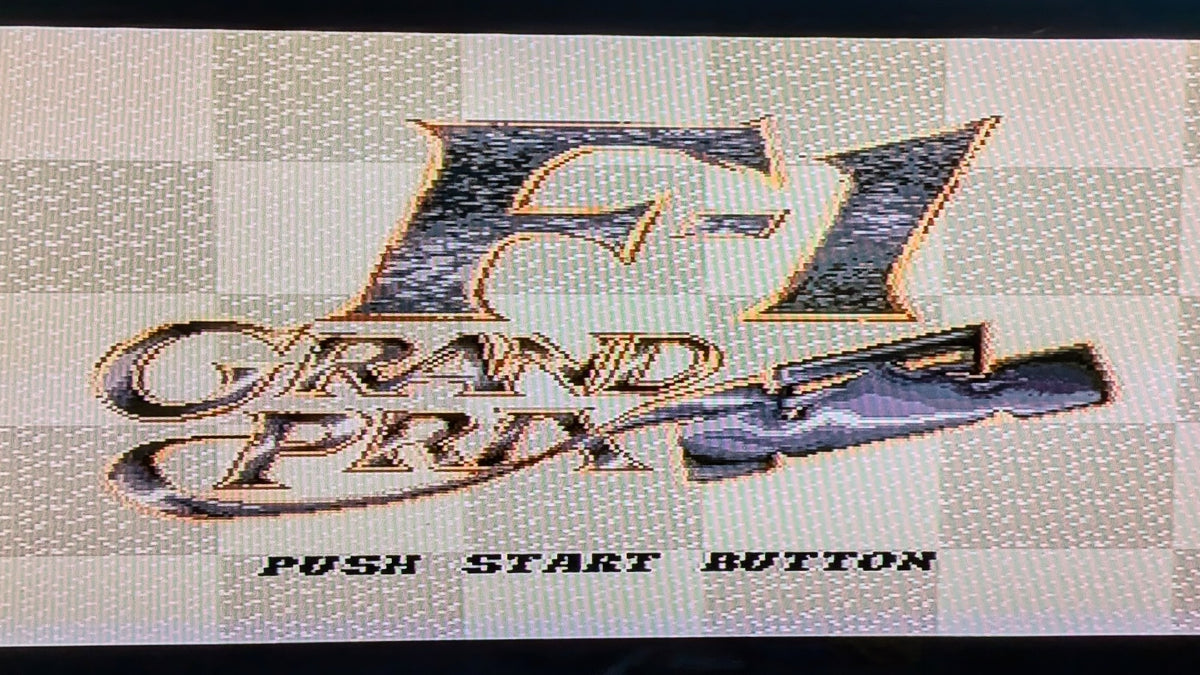 The digital game screen for Nintendo's  F1 Grand Prix, on the Super Famicom (SFC). It features "F-1 Grand Prix" in stylized metallic lettering and the text 'PUSH START BUTTON' on a checkered background. This is to show the game is tested and working.