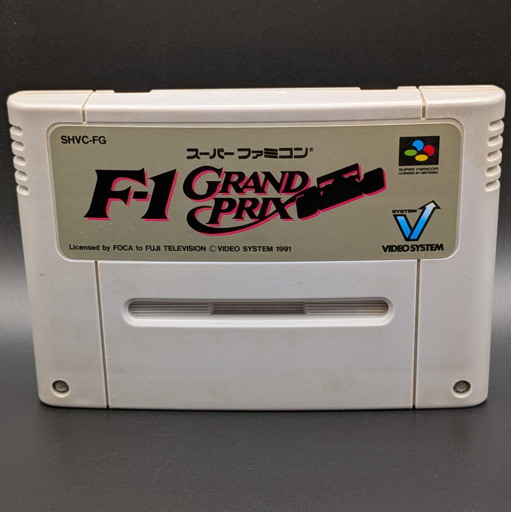 A close up of F-1 Grand Prix video game cartridge for Nintendo's Super Famicom (SFC) Entertainment System, shown standing up and facing forwards on a dark grey background.