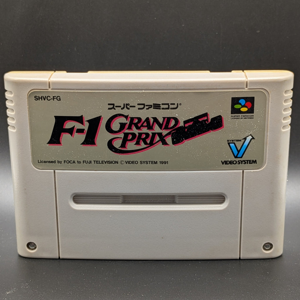 A close up of F-1 Grand Prix video game cartridge for Nintendo's Super Famicom (SFC) Entertainment System, shown standing up and facing forward on a dark grey background.
