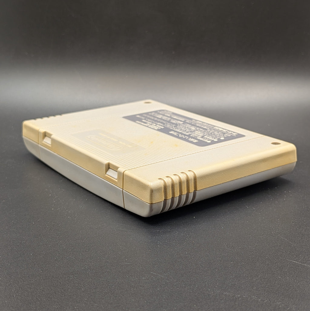 F-1 Grand Prix video game cartridge for Nintendo's Super Famicom (SFC) Entertainment System, shown from an angled top-down view on a dark grey background. You can see yellowing on the back panel.