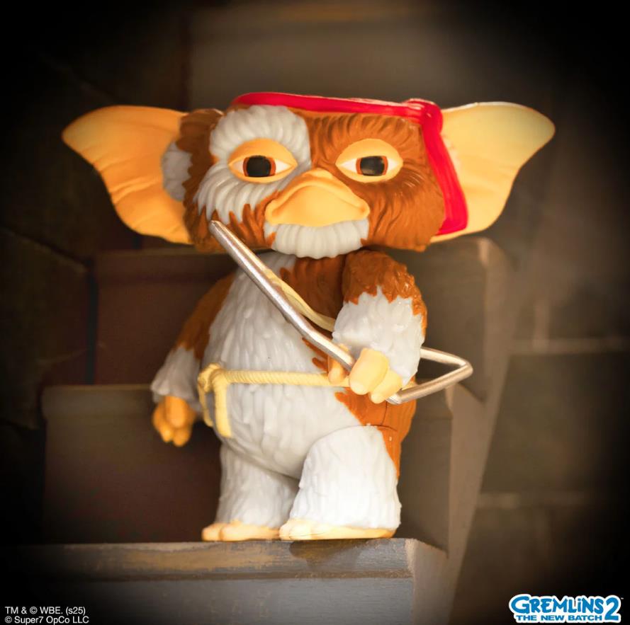 Toy figure of a creature from Gremlins 2 on a dark background