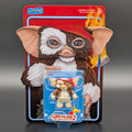 Super7 Gremlins 2 The New Batch action figure in its original blister card packaging, featuring a detailed Gremlin illustration on the backing card and the small figure with a red headband in the clear blister.