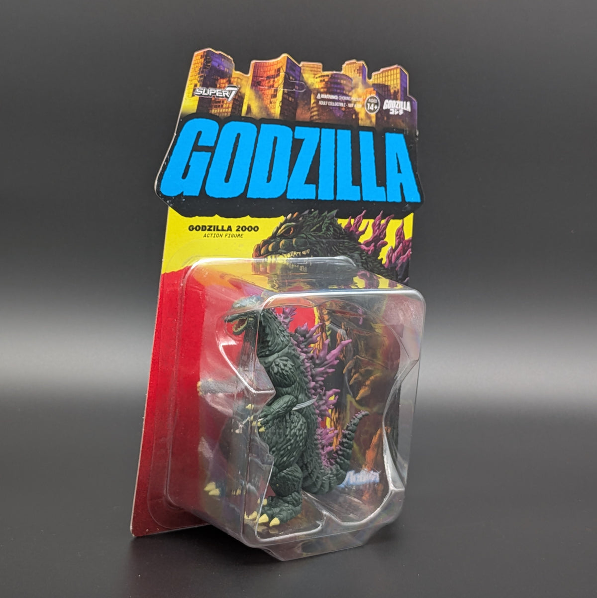 Godzilla 2000 action figure in its original carded packaging, featuring a dark green textured figure inside a clear plastic blister pack with a red and blue backing card.