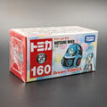 A boxed Dream TOMICA Hatsune Miku toy, shown in its original retail packaging on a dark gray surface. The box features a red and white front panel with the number 160, alongside an illustration of the blue and black character in a car.