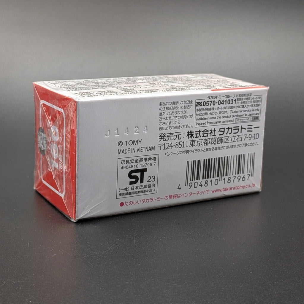A sealed retail box for a Takara Tomy model, showing the back and side panels with Japanese text, a barcode, and a red graphic on a dark gray background.