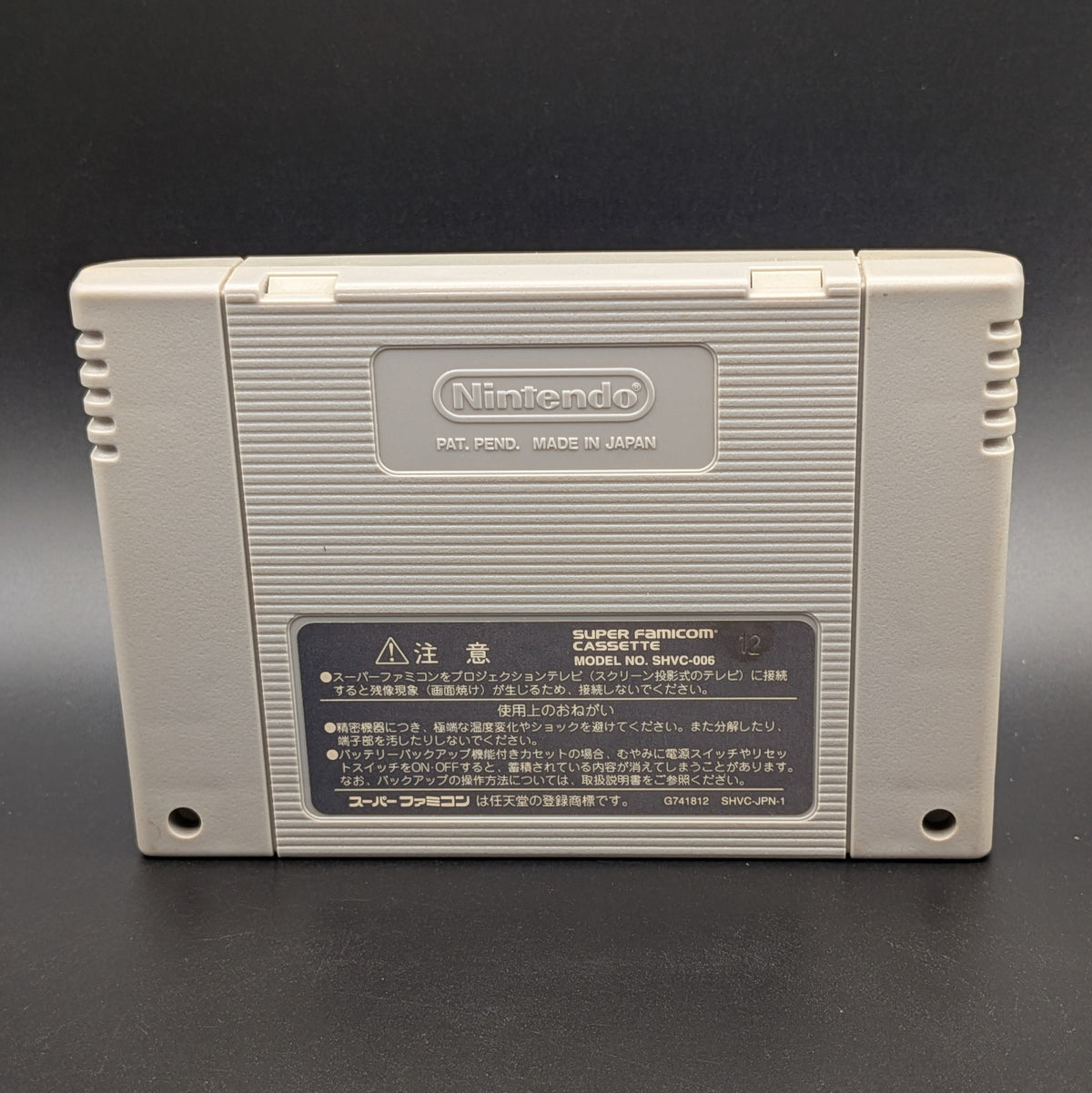 J League Excite Stage '96 video game cartridge for Nintendo's Super Famicom (SFC) Entertainment System, showing the back of the cartridge. It sits on a dark grey background.