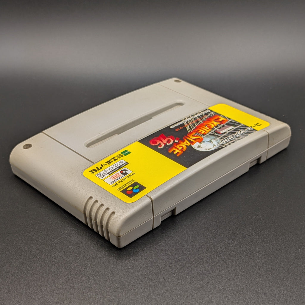 J League Excite Stage '96 video game cartridge for Nintendo's Super Famicom (SFC) Entertainment System, shown laying on its back with the label facing upwards. Showing the right hand side and top edge. The cart is displayed on a dark grey background