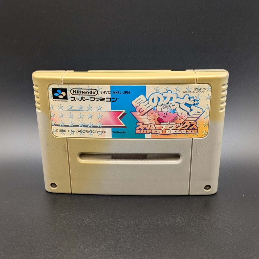 Kirby's Dream Land Super Deluxe video game cartridge for Nintendo's Super Famicom (SFC) Entertainment System, shown standing up and facing forwards. It has large areas of yellowing and the label has faded. Displayed a dark grey background.
