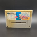 Kirby's Dream Land Super Deluxe video game cartridge for Nintendo's Super Famicom (SFC) Entertainment System, shown standing up and facing forwards. It has large areas of yellowing and the label has faded. Displayed a dark grey background.
