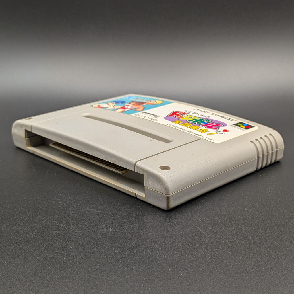 Kunio-Kun no Dodgeball video game cartridge for Nintendo's Super Famicom (SFC) Entertainment System, shown laying on its back with the label facing upwards. Showing the right hand side and bottom slot. It sits on a dark grey background