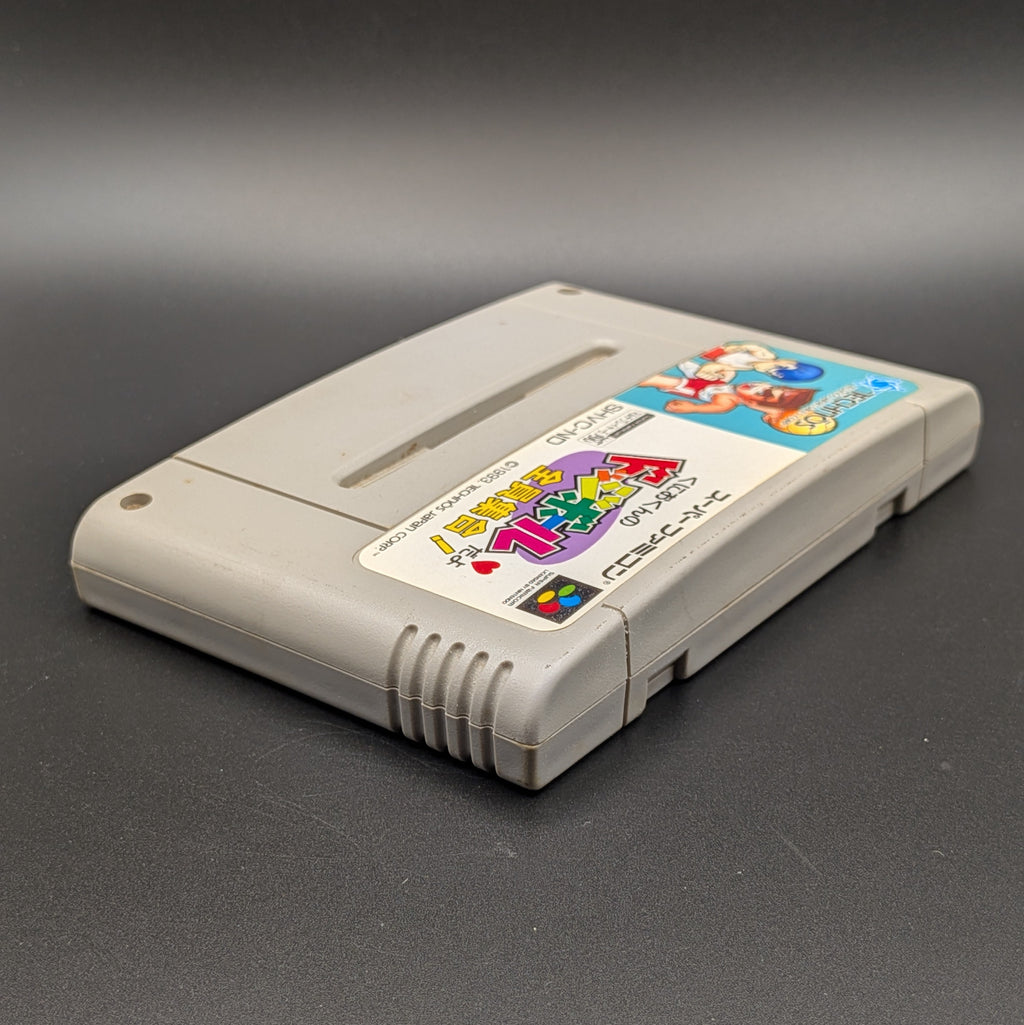 Kunio-Kun no Dodgeball video game cartridge for Nintendo's Super Famicom (SFC) Entertainment System, shown laying on its back with the label facing upwards. Showing the right hand side and top edge. It sits on a dark grey background