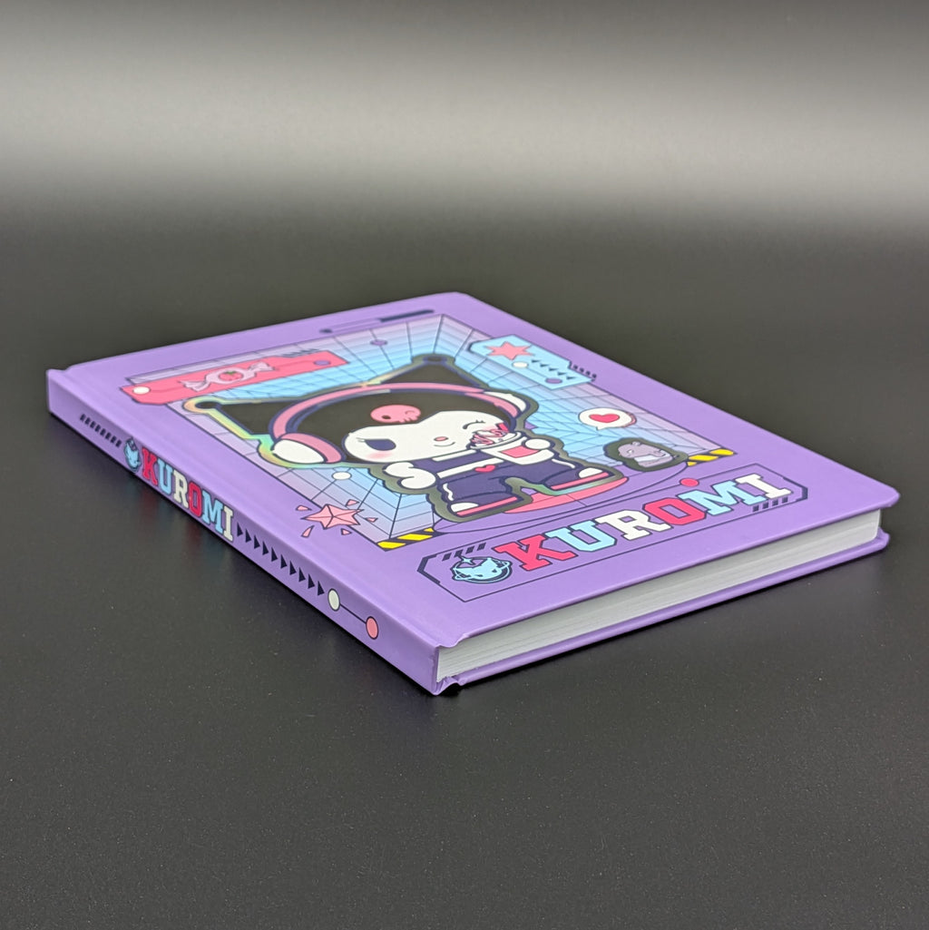 A purple Kuromi ruled notebook with a colourful cartoon cover illustration, laying on its back at a 3/4 view & photographed on a dark grey background. From the Sanrio POP range, printed by Blue Sky Studios.
