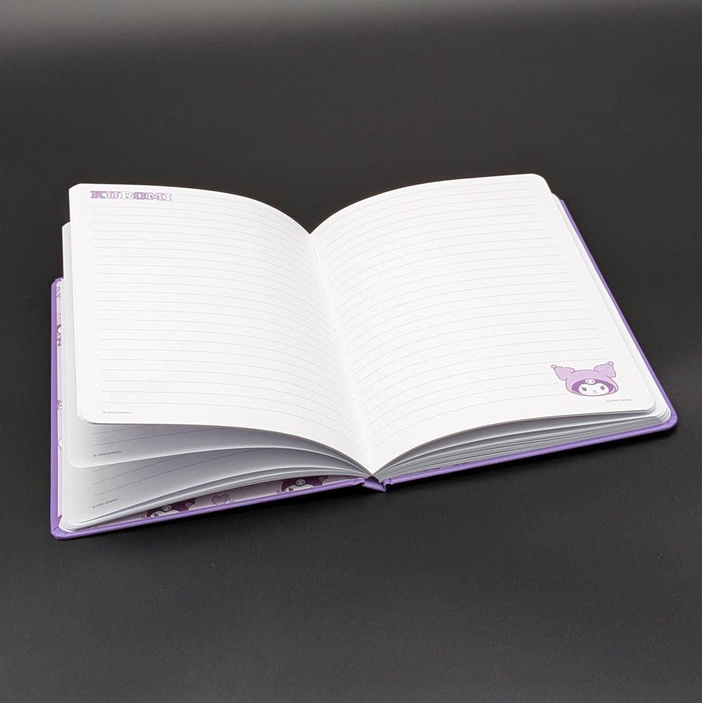 A purple Kuromi ruled notebook laying open revealing the lined paper and Kuromi motiffs in the corners, photographed on a dark gray background. From the Sanrio POP range, printed by Blue Sky Studios.