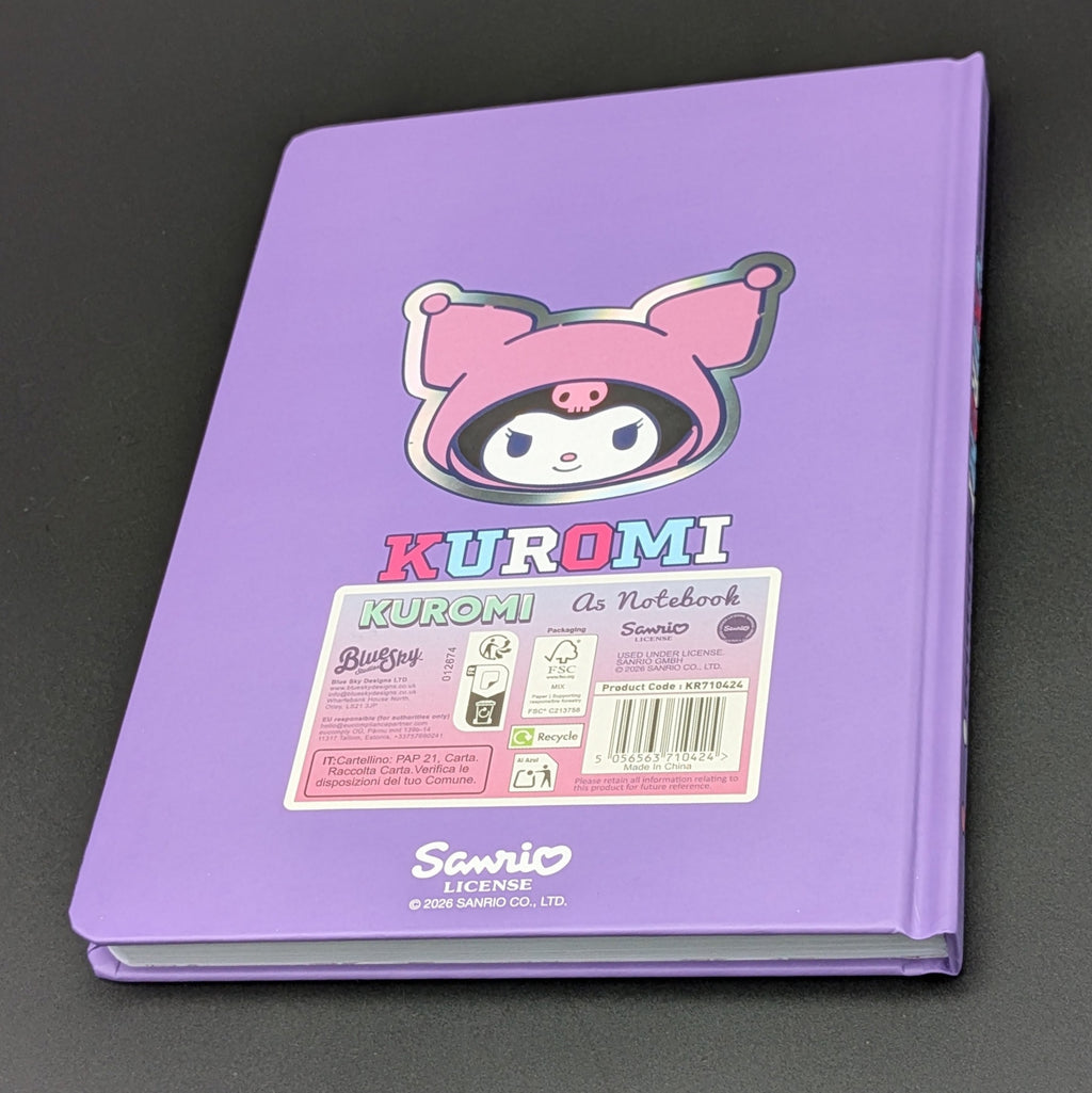 A purple Kuromi ruled notebook with a colourful cartoon illustration on the back and a label with product information, photographed on a dark gray background. From the Sanrio POP range, printed by Blue Sky Studios.