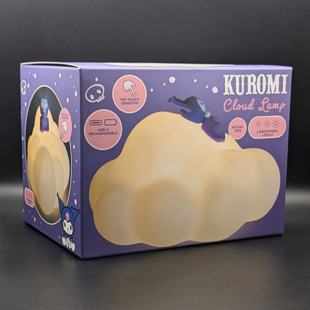 Kuromi Cloud Lamp retail box in purple packaging with a large cream-colored cloud-shaped lamp, photographed on a dark surface against a dark background.