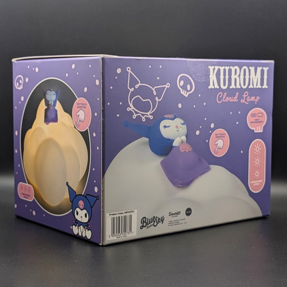 Kuromi Cloud Lamp retail packaging box by Sanrio, featuring a purple box with illustrations of Kuromi on a cloud-shaped lamp and product feature icons, photographed on a dark gray background.