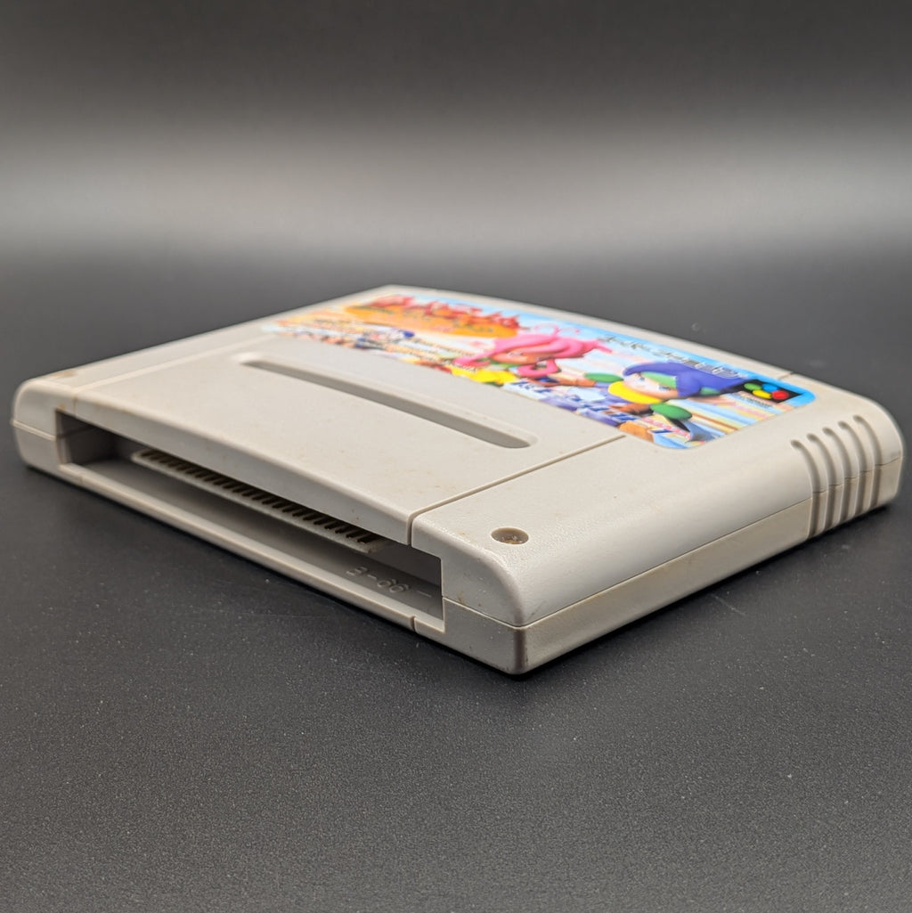 Lode Runner Twin : Justy to Liberty Daibouken video game cartridge for Nintendo's Super Famicom (SFC) Entertainment System, shown laying on its back with the label facing upwards. Showing the right hand side and bottom slot. It sits on a dark grey background