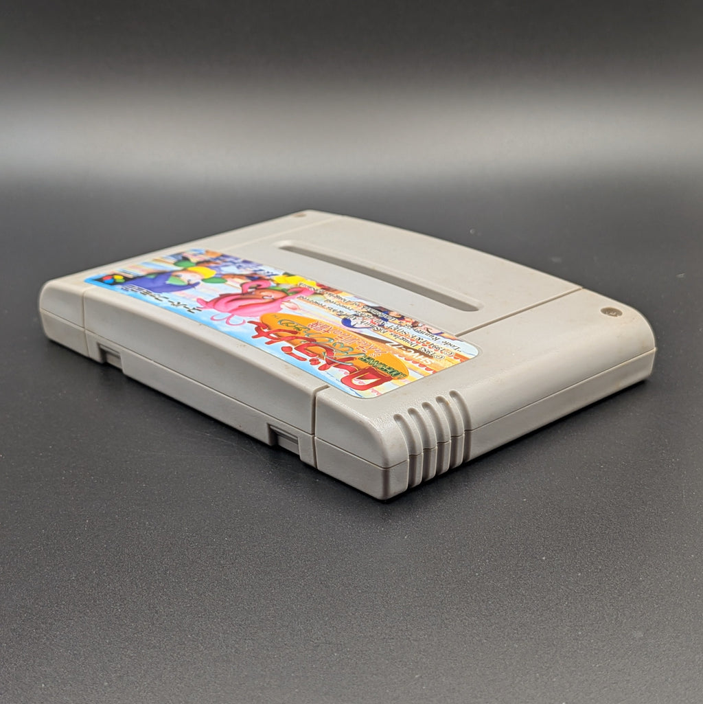 Lode Runner Twin : Justy to Liberty Daibouken video game cartridge for Nintendo's Super Famicom (SFC) Entertainment System, shown laying on its back with the label facing upwards. Showing the left hand side and top edge. It sits on a dark grey background.