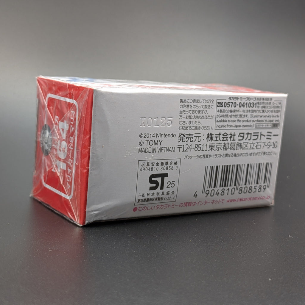 Nintendo Tomica box packaging, showing the back side with Japanese text, barcode, and product information on a dark gray surface.