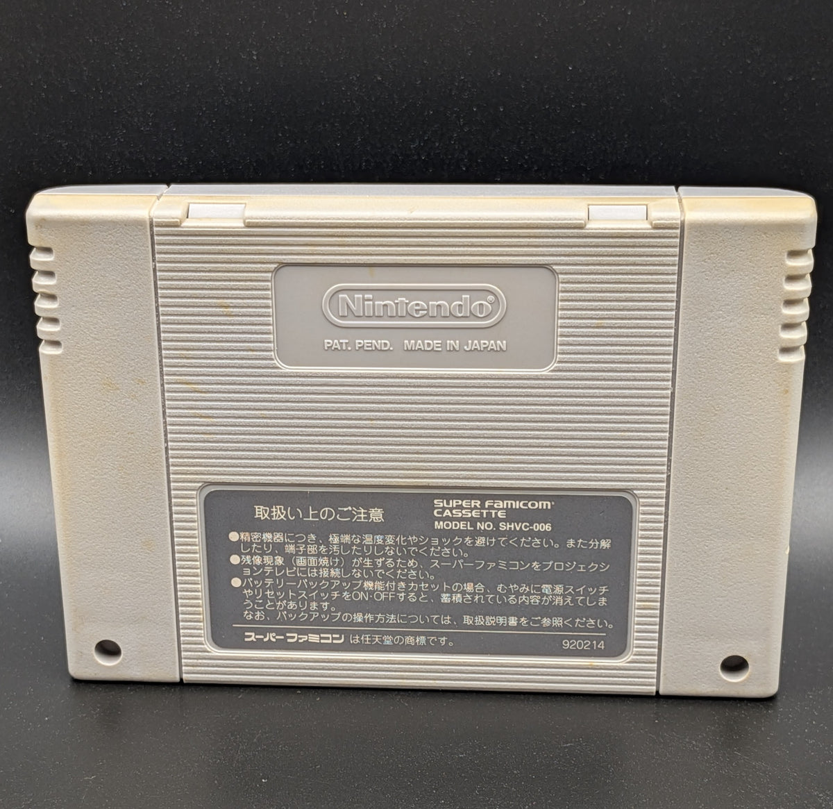 Mickey's Magical Adventure video game cartridge for Nintendo's Super Famicom (SFC) Entertainment System, showing the back of the cartridge. It sits on a dark grey background.